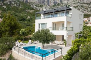 a villa with a swimming pool and a house at Villa Lukić in Makarska