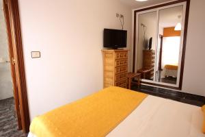 a bedroom with a bed and a mirror and a television at Hostal San Roque in Portonovo +75 photos
