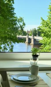una mesa con un plato y un jarrón en una ventana en River Apartment, en Pärnu