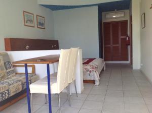 a room with a table and a couch and a bedroom at Quinta do Atlantico in Santa Bárbara de Nexe