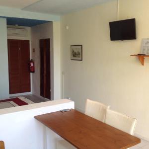 a dining room with a table and a television on the wall at Quinta do Atlantico in Santa Bárbara de Nexe