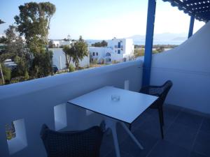 een tafel en stoelen op een balkon met uitzicht bij Nikoletta Studios in Agios Prokopios