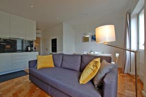 a living room with a blue couch with yellow pillows at Downtown Cathedral Apartment in Braga