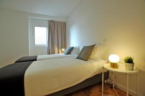 a bedroom with a large white bed and a table at Downtown Cathedral Apartment in Braga