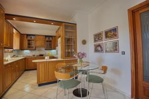 a kitchen with a glass table and chairs at Lidromi Home (Iris) in Patitiri