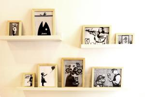 a shelf with framed pictures on a wall at GregBnb-com - T2 Cosy et design - PARKING INCLUS - WiFi - 15min Gare in Toulon