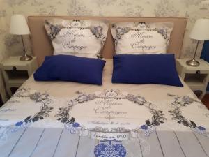 a bed with blue and white sheets and pillows at Villa SAINT-PRIVAT in Pouzilhac