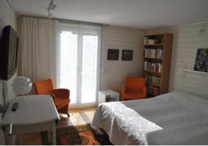 um quarto com uma cama, uma secretária e cadeiras em Room In Ekestad em Ekestad