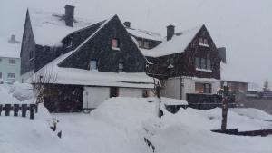 a large house covered in snow with snow at Springer-Apartment-1215 in Kurort Oberwiesenthal