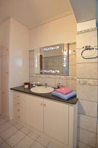 a bathroom with a sink and a mirror at Lidromi Home (Iris) in Patitiri