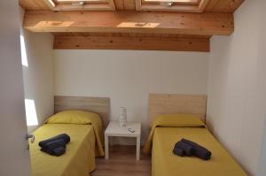 2 bedden in een kamer met houten plafonds bij Eleven in Siracusa