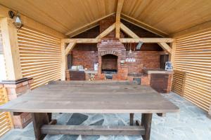 - une grande table en bois dans une pièce avec un four en briques dans l'établissement Licurici, à Colibiţa