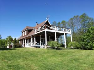 a large house on a field with a grass yard at Lakeshore house in Dvarčėnai +41 photos