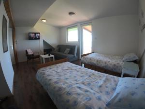 a small bedroom with two beds and a couch at Mazurska Kwatera-Rezerwat Fuledzki Róg in Giżycko