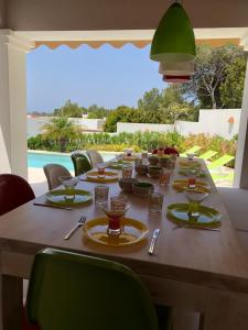 a long wooden table with plates and glasses on it at Es Queixal - Can Canet con piscina exterior climatizada in Cala Vadella
