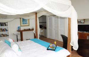 1 dormitorio con 1 cama con dosel blanco en Villa Cleavage, en Simpson Bay
