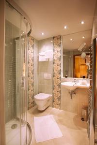 a bathroom with a shower, toilet, sink and tub at Green Garden Hotel in Prague