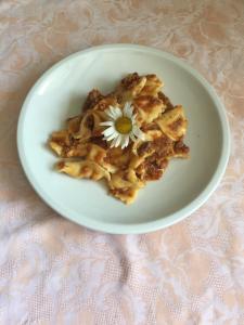 a plate of food with a flower on top of it at Agriturismo Ca' di Racc in Gromo