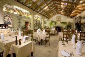 a restaurant with white tables and chairs and a ceiling at Green Garden Hotel in Prague