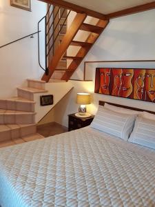 una camera con un grande letto e una scala di La Villa a La Spezia
