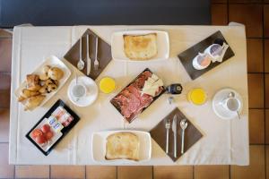 una mesa con platos de desayuno. en HostalTina, en Bossòst