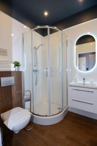 uma casa de banho com um chuveiro, um WC e um lavatório. em Cracow Apartaments III em Cracóvia