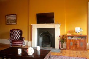 sala de estar con chimenea y TV encima. en Hopetoun Grande Georgian Apartment, en Edimburgo