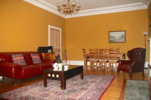 a living room with a red couch and a table at Hopetoun Grande Georgian Apartment in Edinburgh
