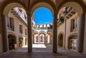 an empty arcade in a building with columns at B&B Dimora Tomasi in Palermo