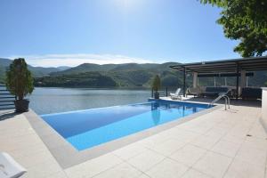 a swimming pool with a view of a lake at Villa Tikvesh Lake in Kavadarci