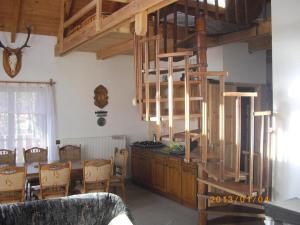 a living room with a wooden spiral staircase in a room at Csalavér-Vendégvadászház in Noszvaj