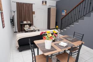 a room with a bed and a table with flowers on it at Villa NOTOS in Makry Gialos