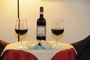 una bottiglia di vino e due bicchieri su un tavolo di Albergo Duomo a Montepulciano