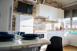 Una cocina con gabinetes blancos y una mesa con sillas. en Alojamientos Teatro, en Porcuna