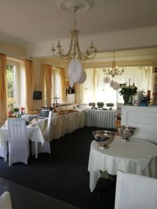 a room with several tables with white table cloths at Elbhotel Bleckede in Bleckede