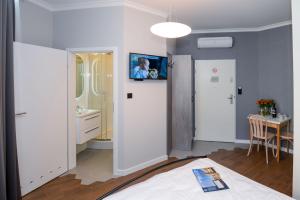 クラクフにあるCracow Apartaments IIIのベッド1台、バスルーム(テーブル付)が備わります。