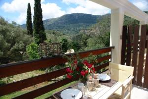 a table on a balcony with a view of the mountains at Medusa Lux Apartments in Liapades