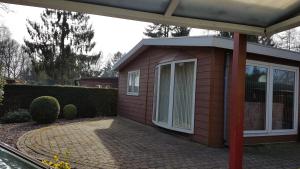 uma pequena casa de tijolos vermelhos com um pátio em Deluxe Holiday Home em Putten