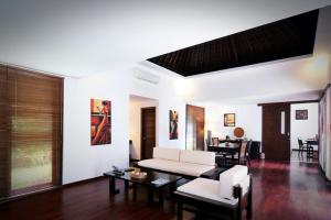 a living room with a white couch and a table at Kebun Villas & Resort in Senggigi