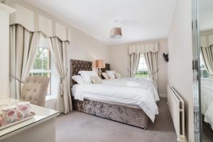 a white bedroom with a large bed and windows at Friars Quarter House B&B in Ballinrobe