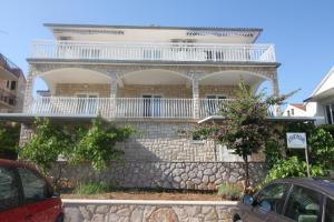 a house with a balcony on top of a stone wall at Apartments Marinko in Stari Grad