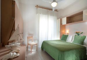 sypialnia z zielonym łóżkiem i krzesłem w obiekcie Hotel Felix w Rimini