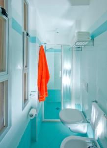 a blue bathroom with a toilet and a shower at Hotel Felix in Rimini