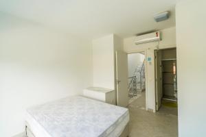 a white room with a bed and a hallway at Villaggio Juquehy in Juquei