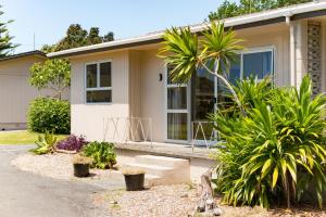 
a house with a patio and a tree at Te Tiriti Units in Paihia
