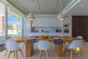 una cucina con un grande tavolo in legno e sedie bianche di Platja de Muro - 2183-30 Mallorca a Muro