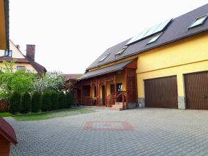 una casa amarilla con garaje y entrada en Noclegi u Zosi, en Maniowy