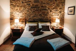 a bedroom with a large bed with two lamps on tables at Varandas da Capela in Tuizelo