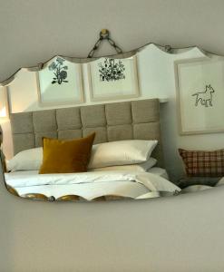 a bedroom with a large mirror above a bed at Dandaleith Cottage No.2 in Craigellachie