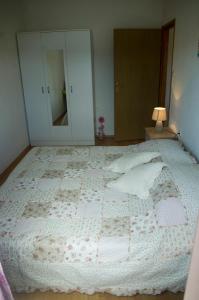 ein Schlafzimmer mit einem großen weißen Bett mit Kissen in der Unterkunft Apartmani Bartulović in Blace